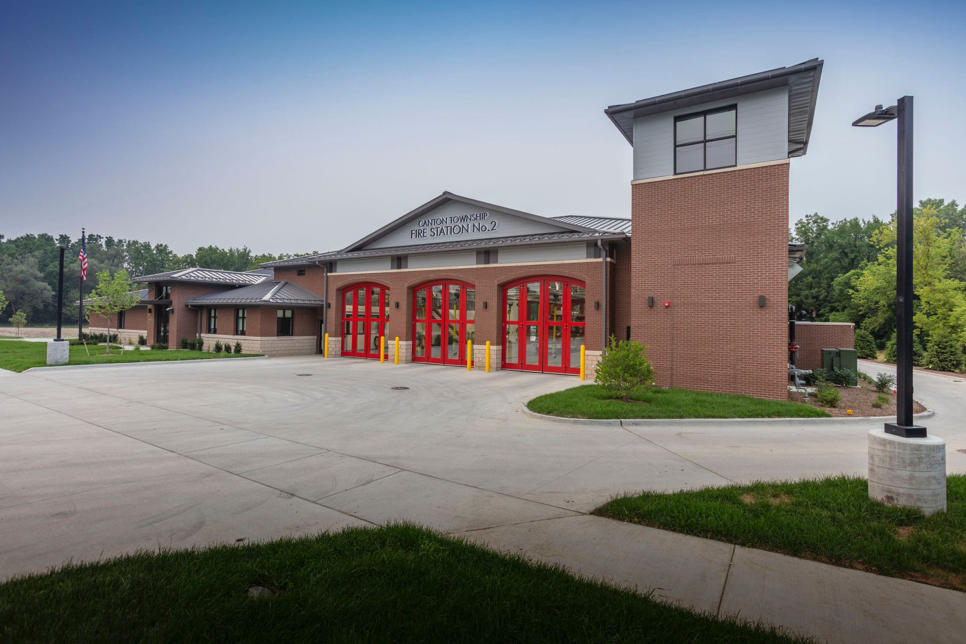 Fire station with red doors and a tall brick tower.