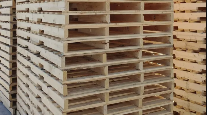Stacks of unfinished wooden pallets in a warehouse or storage area.