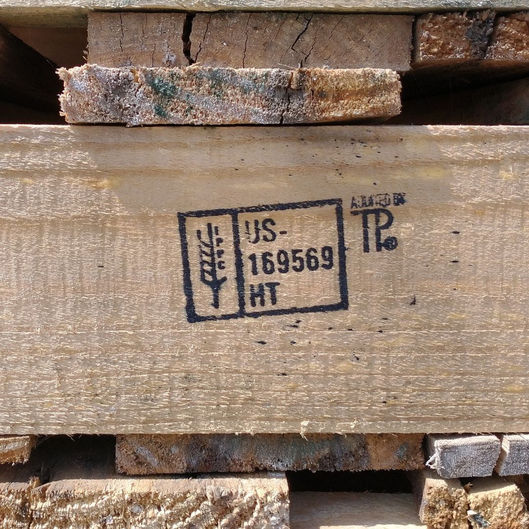 Close-up of stacked lumber with a stamped wood grade mark on the board.