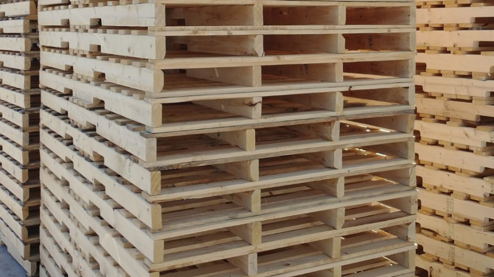 Stacks of empty wooden pallets in a warehouse