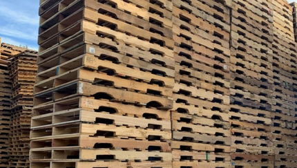 A large stack of wooden pallets stacked on top of each other.