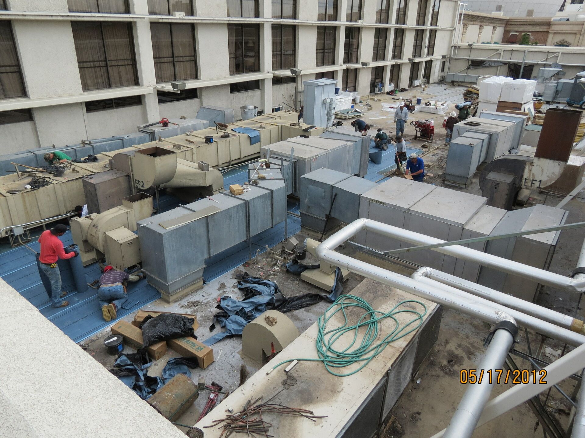 A group of people are working on the roof of a building.