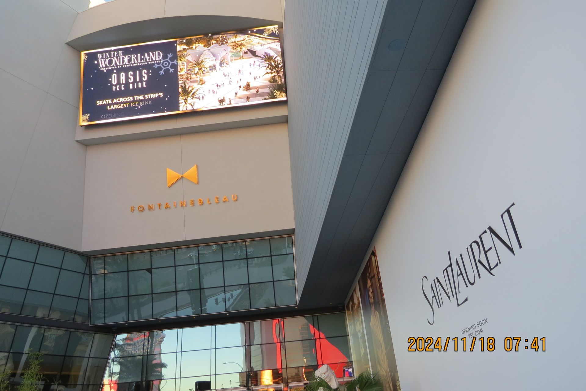 Exterior of a building with a large display screen and Yves Saint Laurent advertisement.