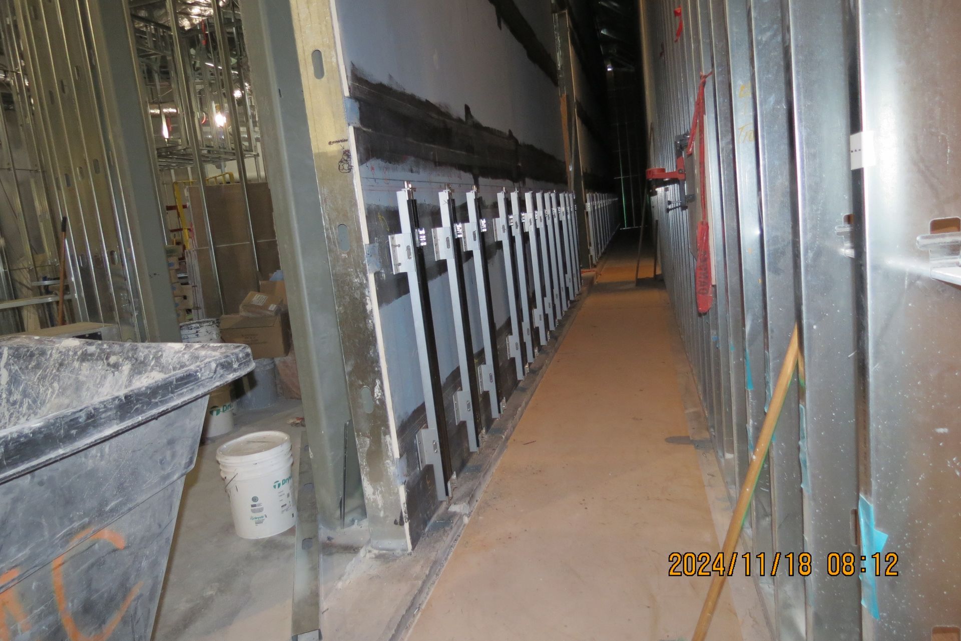 Construction site: metal studs, unfinished walls, narrow hallway.