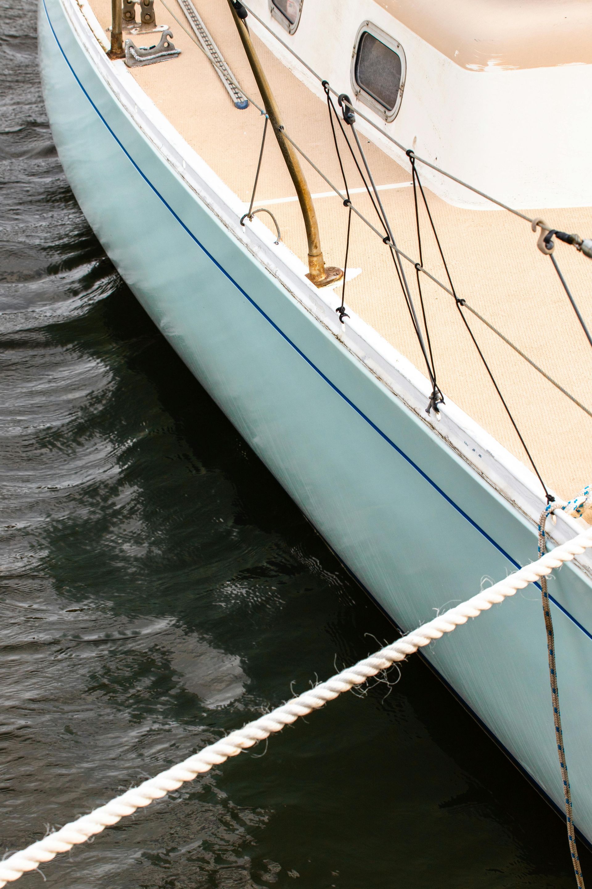 A light blue sailboat docked