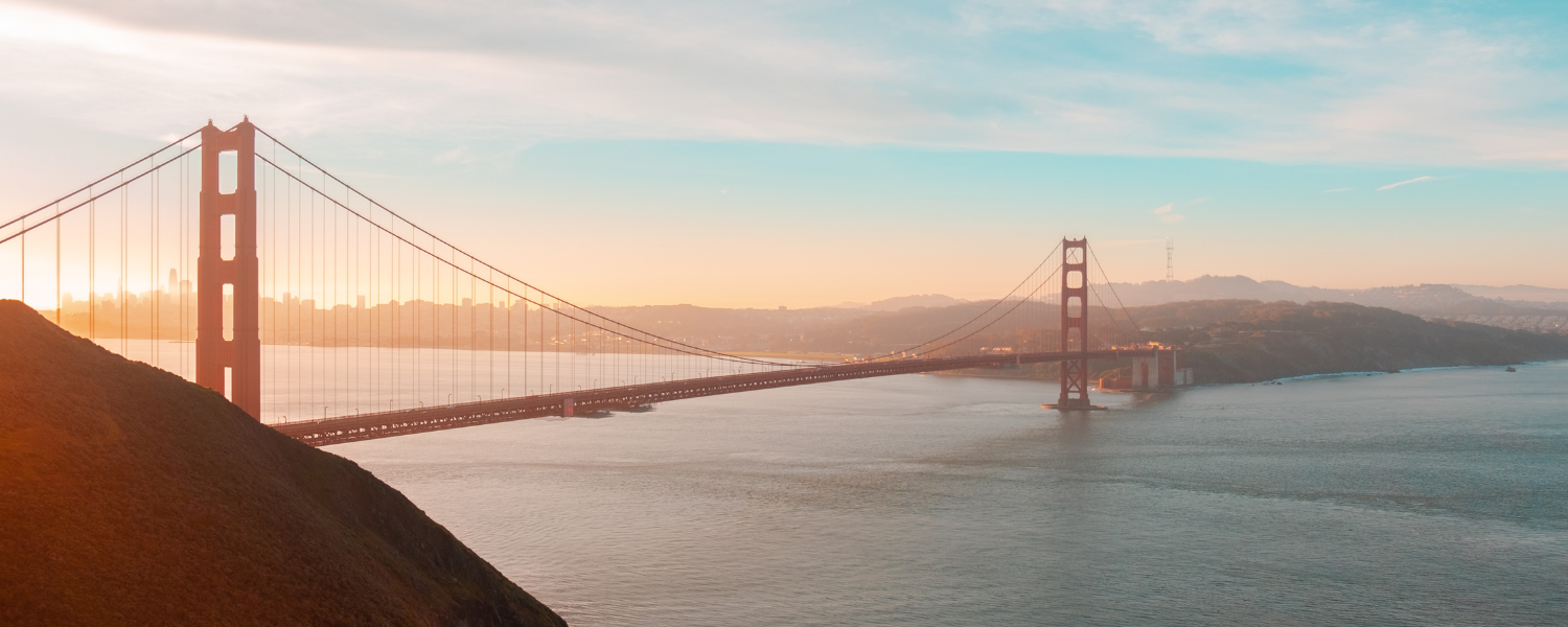 Golden Gate Bridge over water at sunrise.