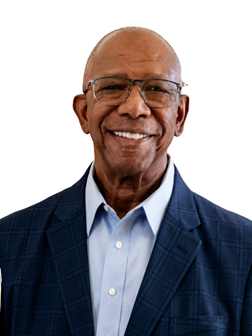 Smiling man wearing glasses, blue shirt, and navy blazer, against a white background.