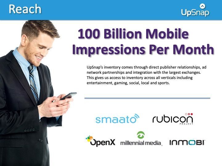 A man in a suit and tie is looking at his cell phone.