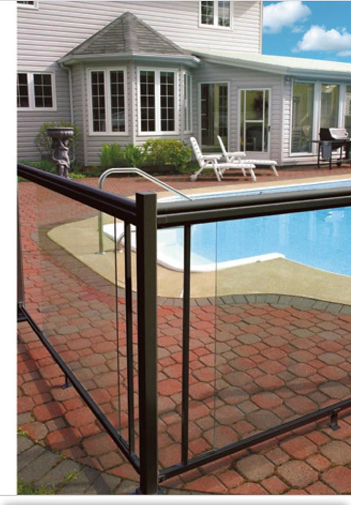 Backyard pool with a glass safety fence and a house patio in the background