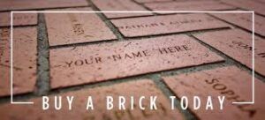 A close-up of engraved red bricks on a walkway with the text