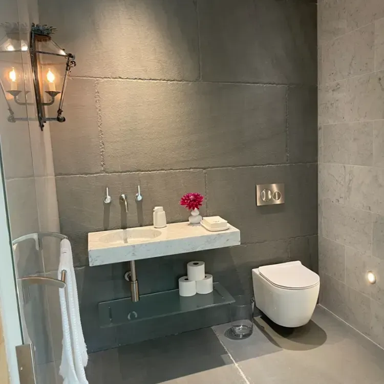 A bathroom with a toilet a sink and a light