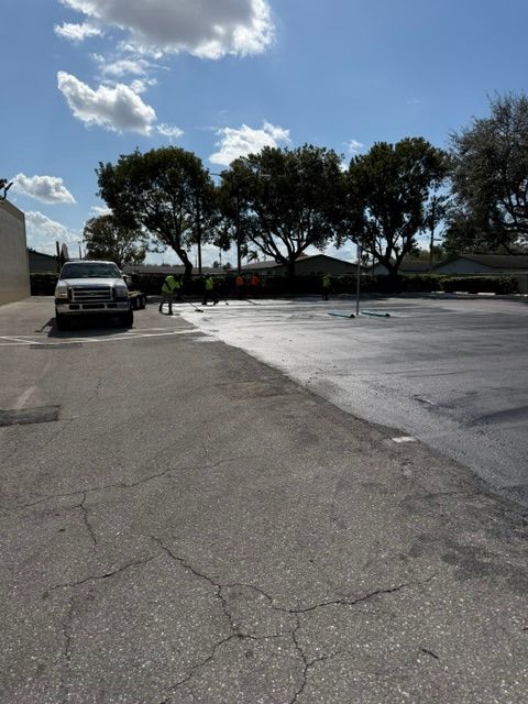 Parking lot with a parked pickup truck, trees, and bright cloudy sky
