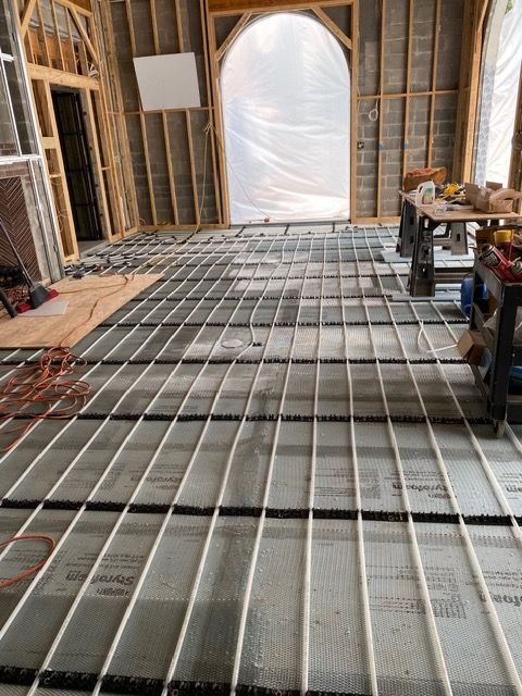 Unfinished house interior with exposed framing and a metal floor grid under construction.