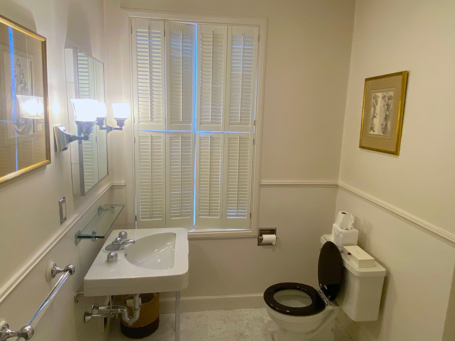 A bathroom with a toilet , sink and mirror.