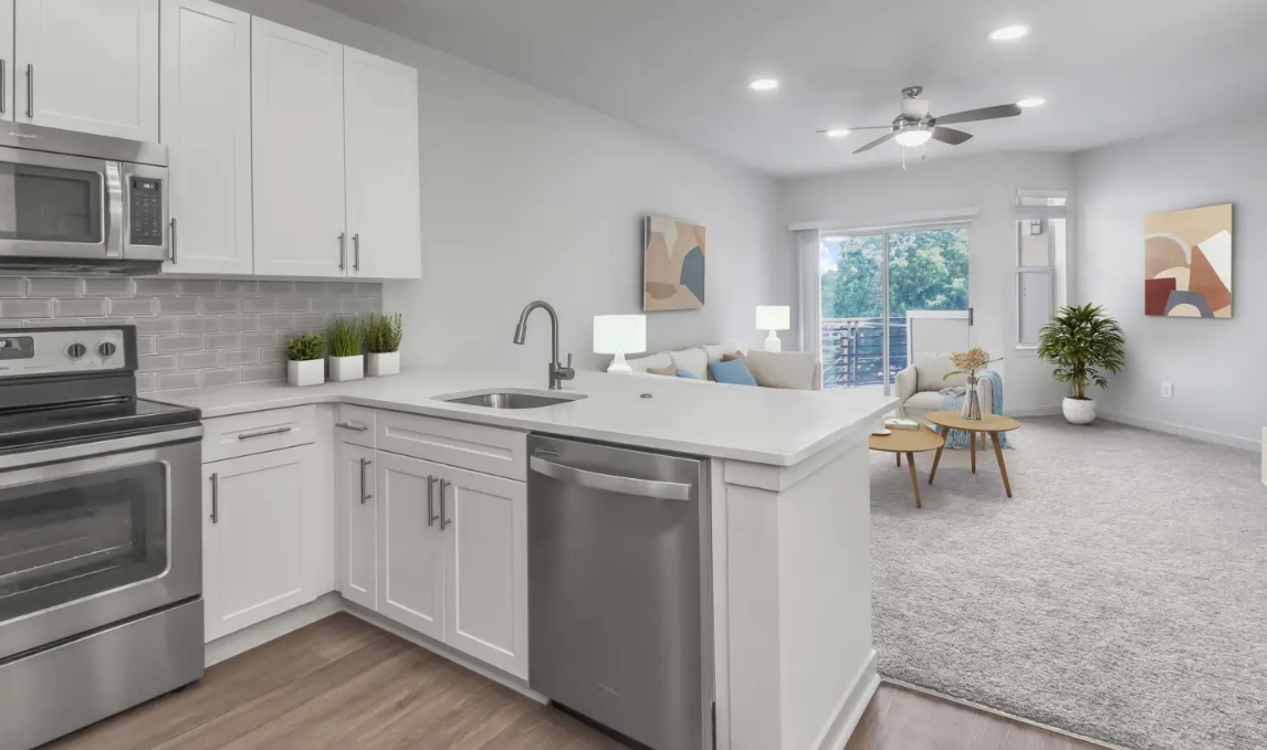 Bright modern kitchen and dining area with white cabinets, stainless appliances, and sliding glass doors to a patio