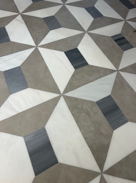 Geometric patterned floor tiles in gray, white, and beige tones