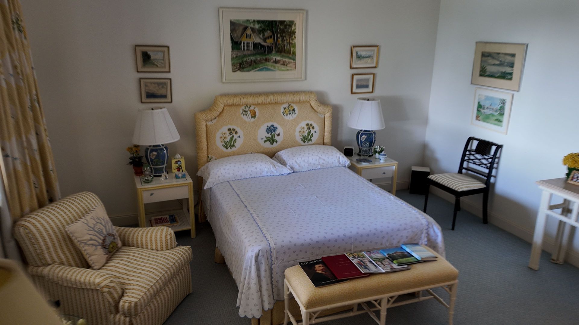 Cozy bedroom with a double bed, armchair, bedside tables, and framed wall art.