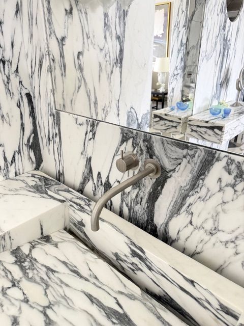 Marble bathroom sink and mirror with wall-mounted faucet and vanity counter