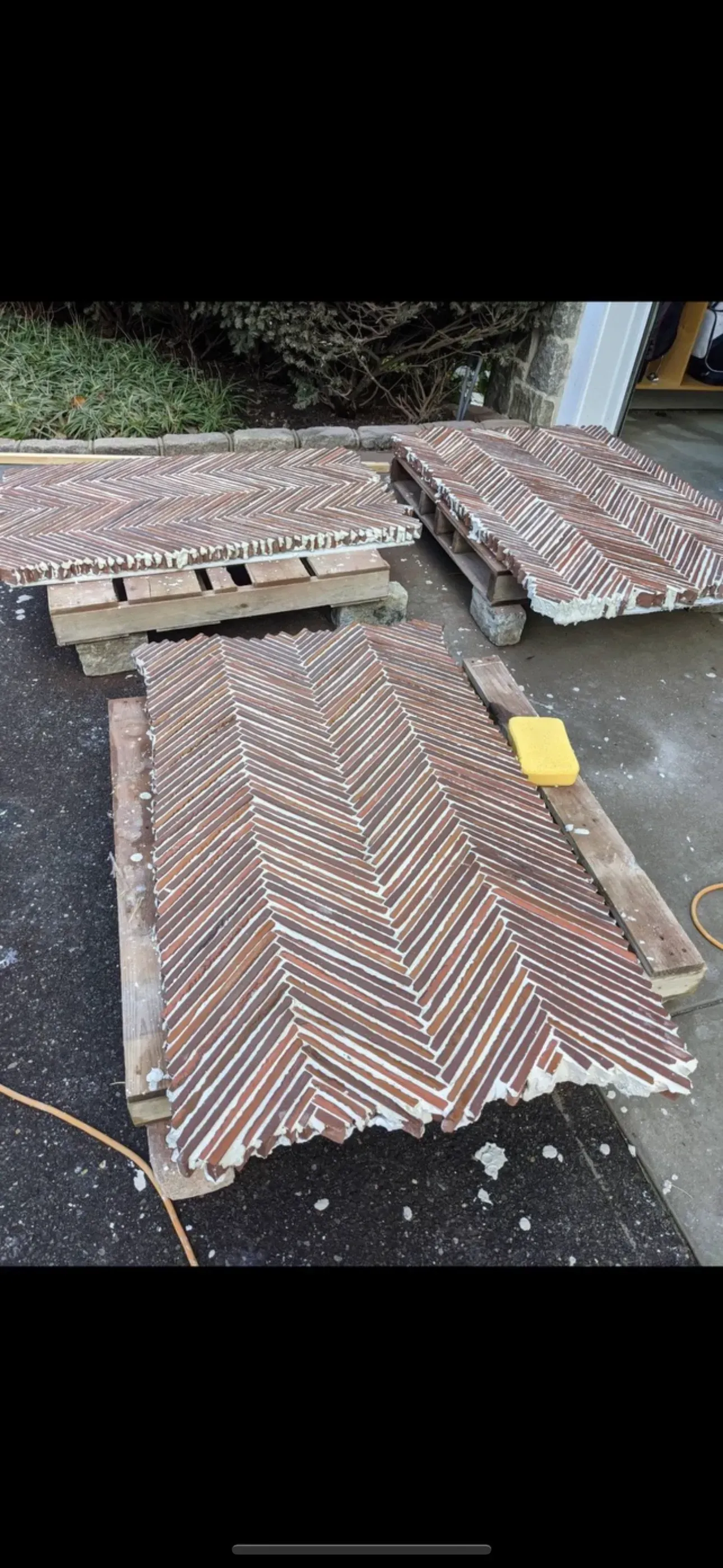 Rooftop with weathered corrugated metal sheets and a wooden pallet on wet ground