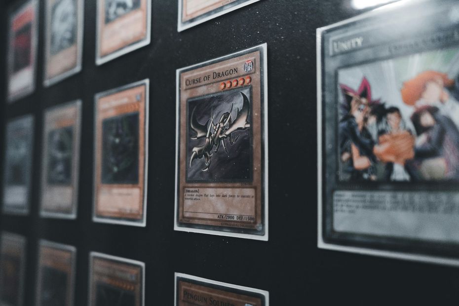 Framed trading cards displayed in rows on a dark wall, with a focused card in the center.