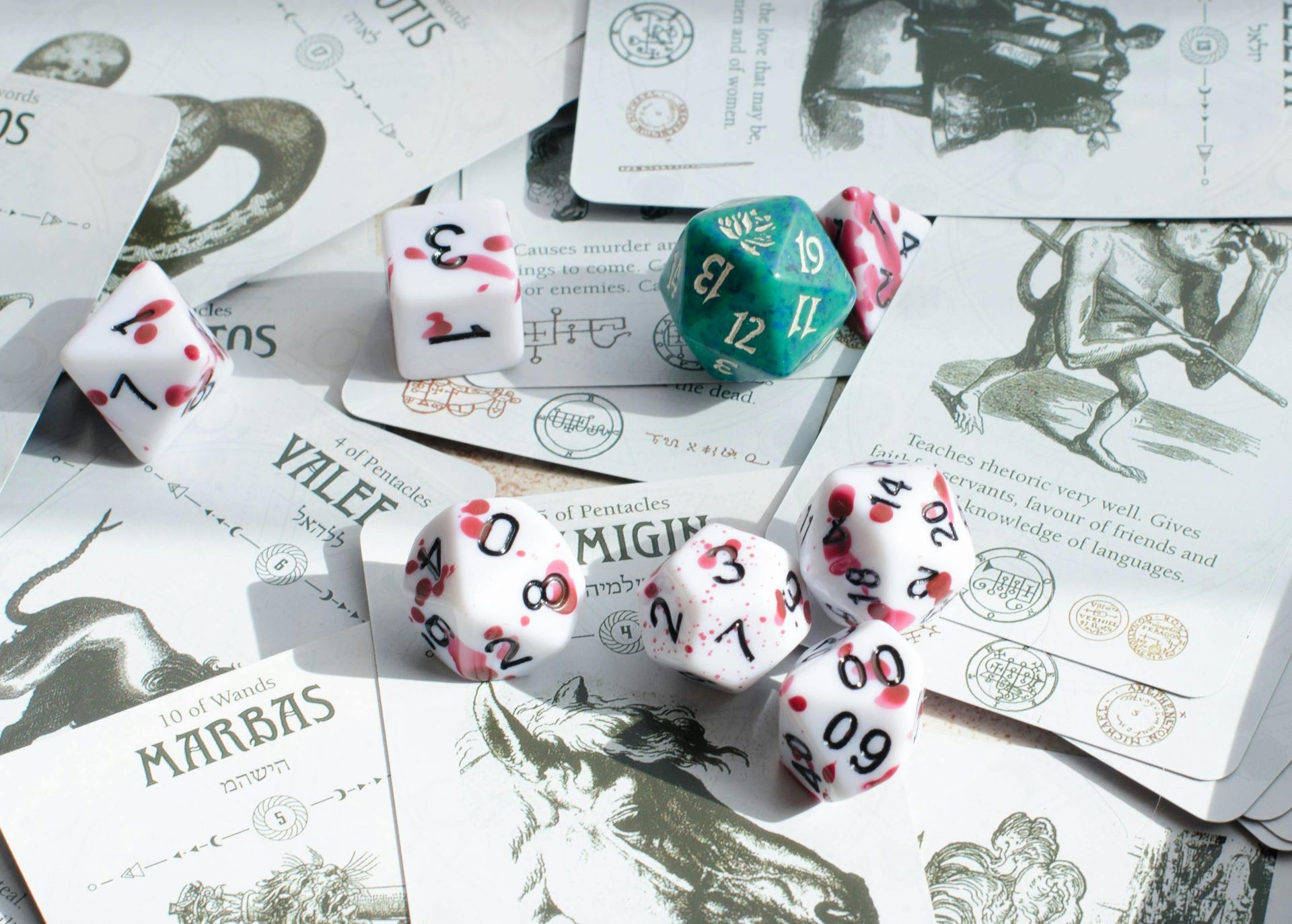 Assorted colorful dice scattered over illustrated tarot cards on a light surface.