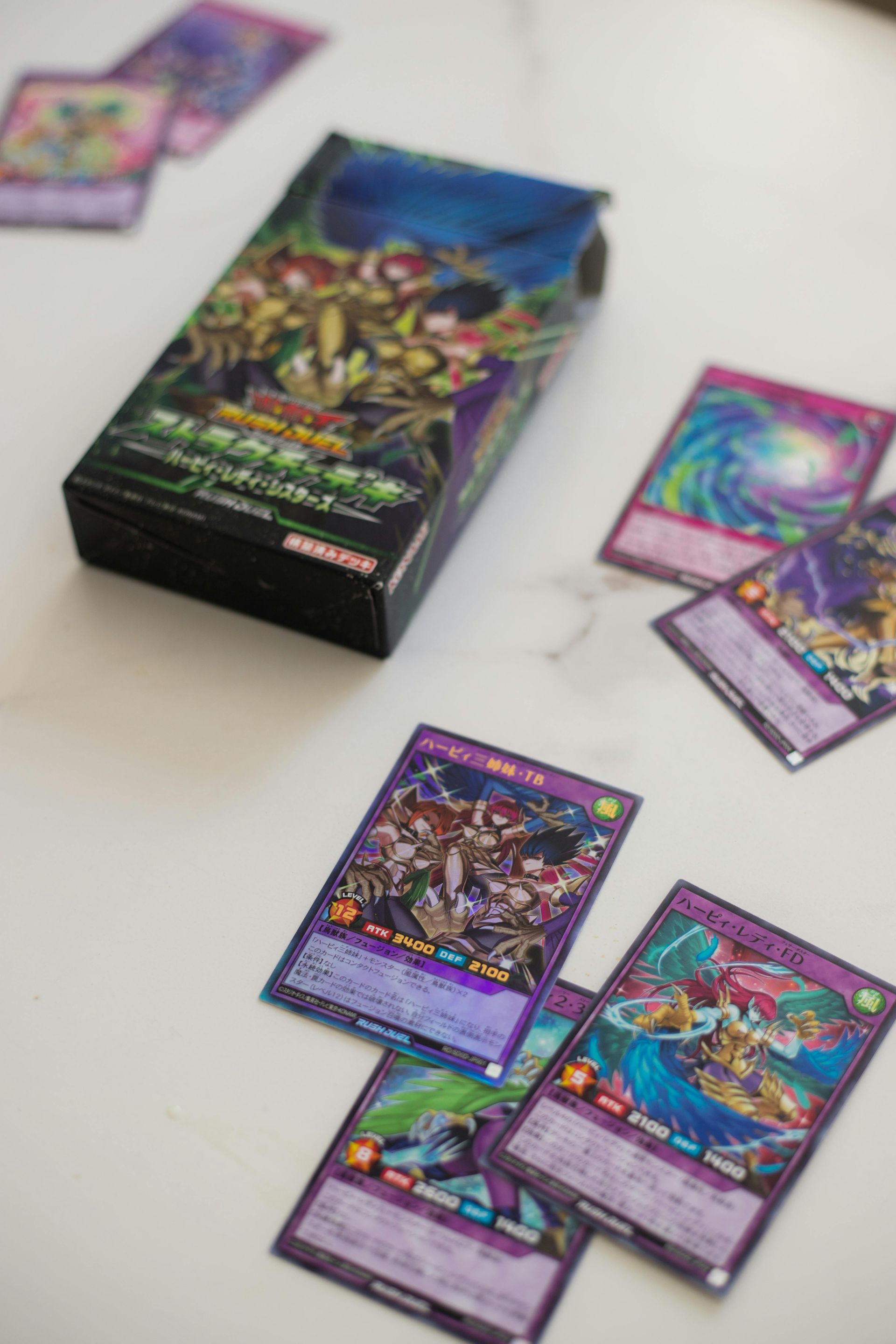 Yu-Gi-Oh card packs and loose holographic cards scattered on a white table.