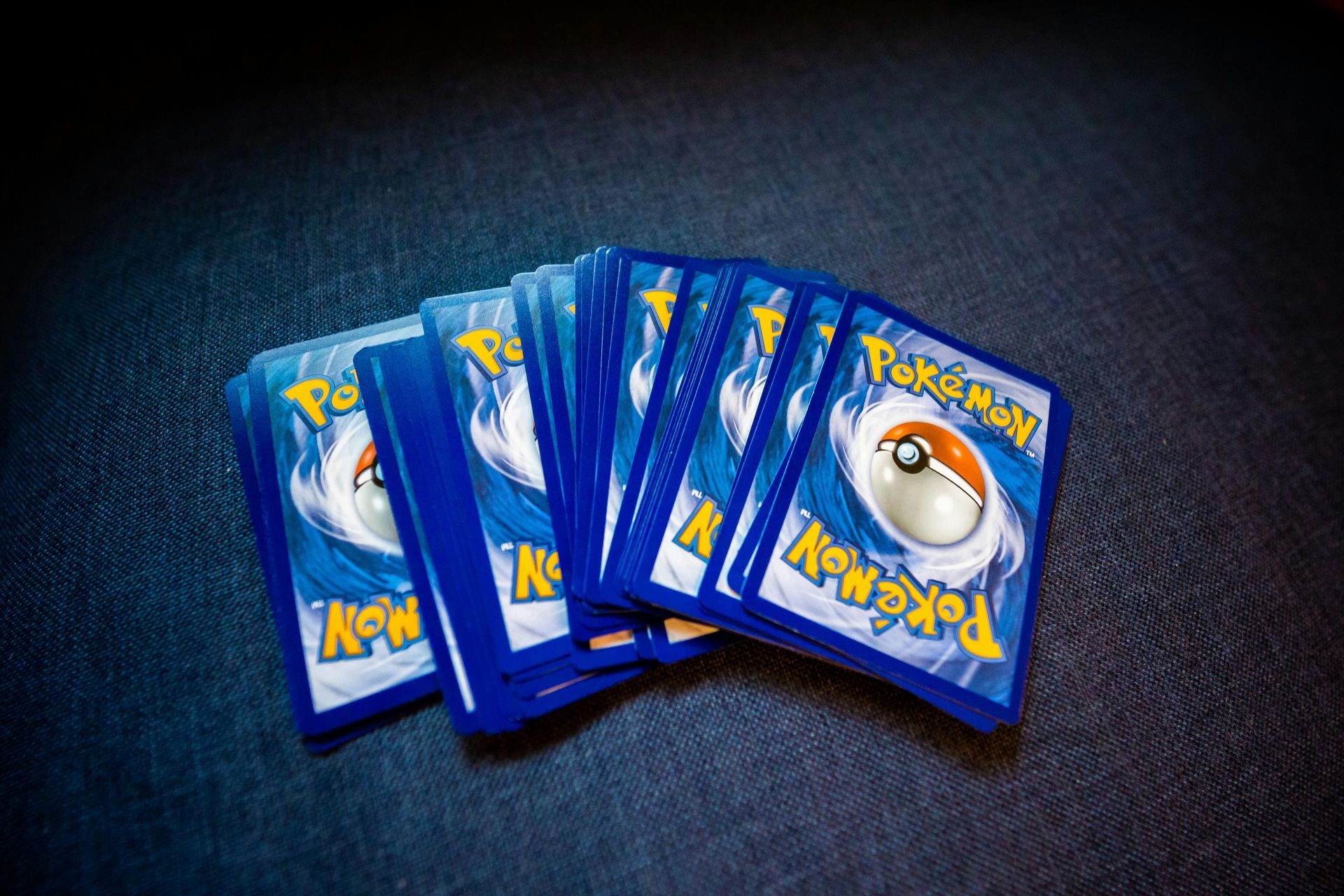 Fan of blue Pokémon cards on a dark background