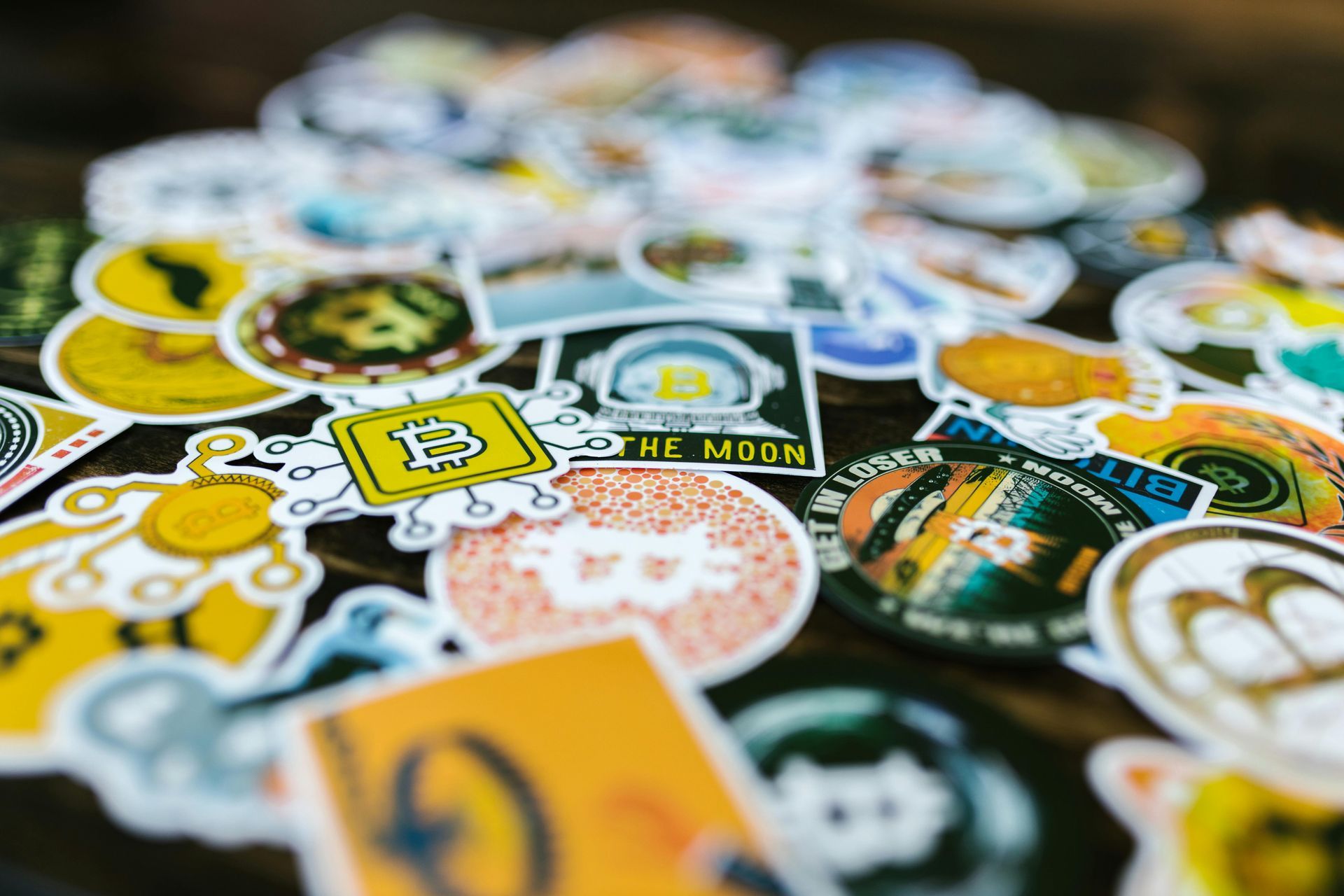 Assorted colorful sticker designs scattered in a pile, including yellow, green, and white graphics.