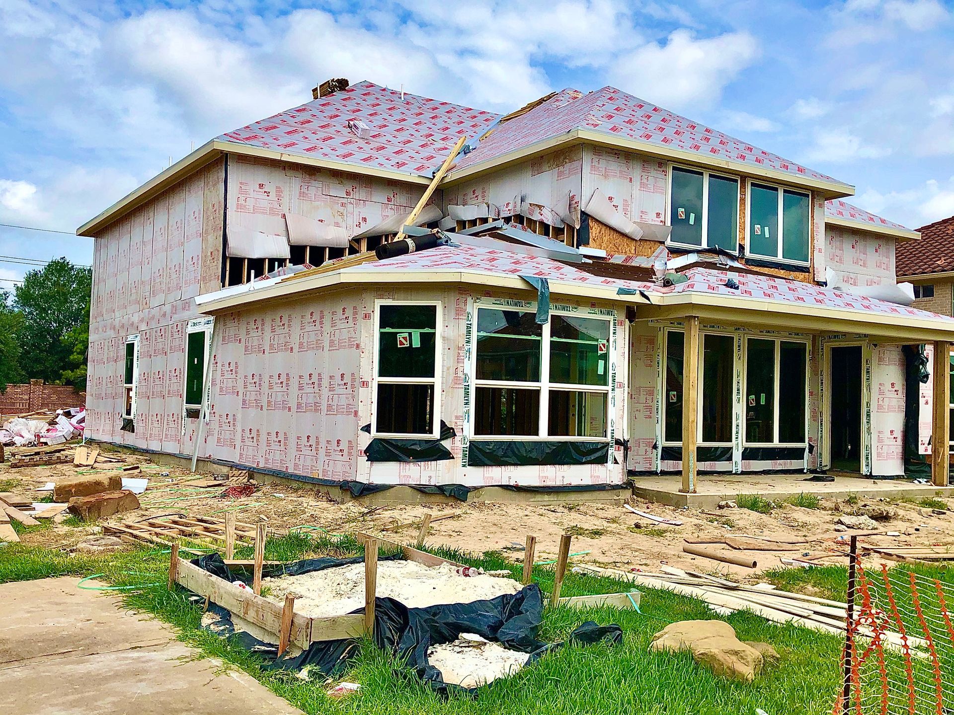 Partially built two-story house with unfinished exterior walls and exposed construction site