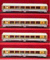 A set of four model trains sitting on top of each other on a red surface.
