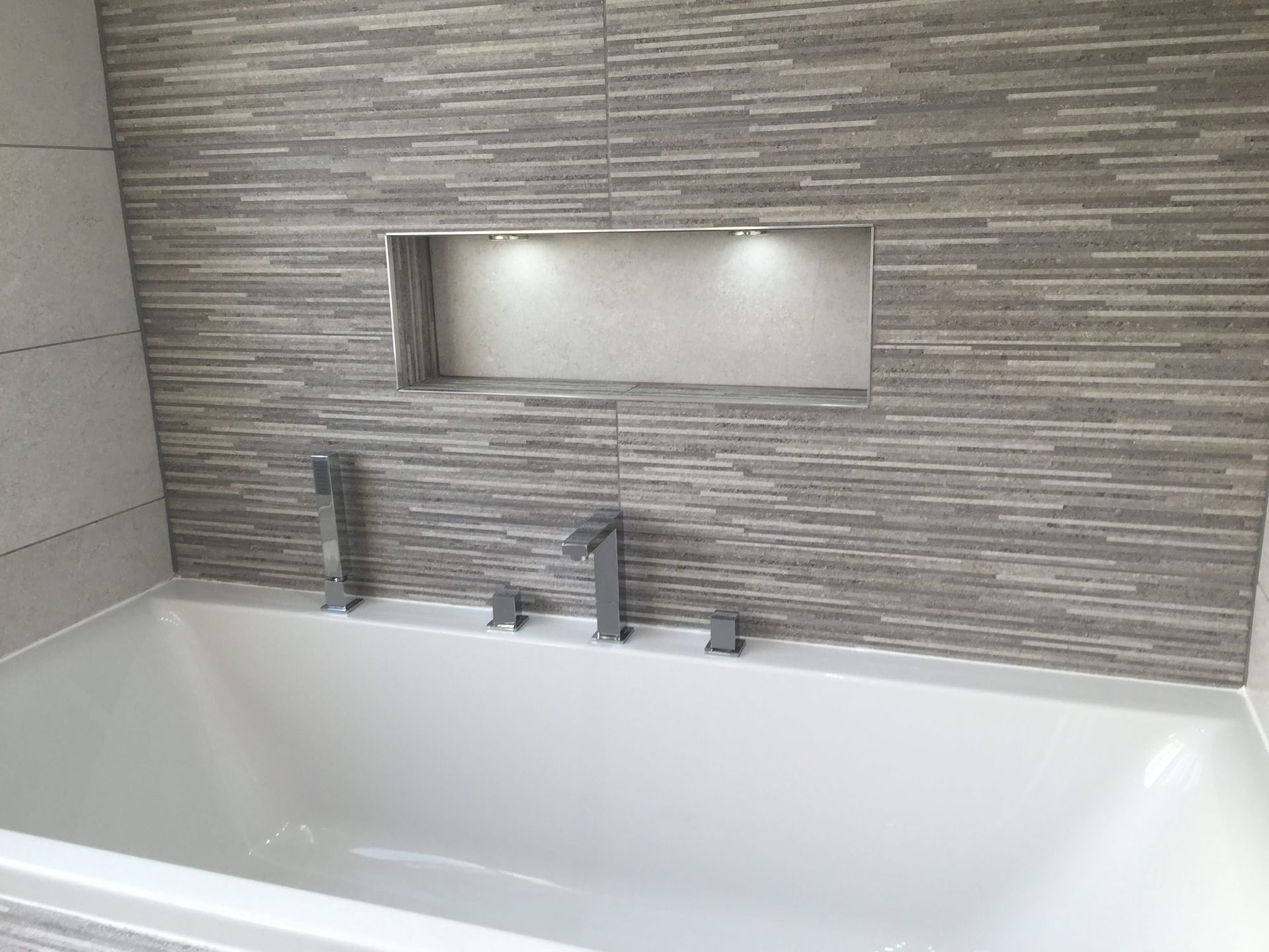 Bath with tiled niche and textured feature wall, fitted by MHC Bathroom Installations