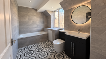 En-suite with patterned floor tiles and an LED mirror