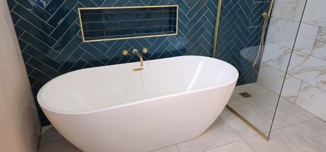 Freestanding bath and teal herringbone feature wall fitted by MHC Bathroom Installations