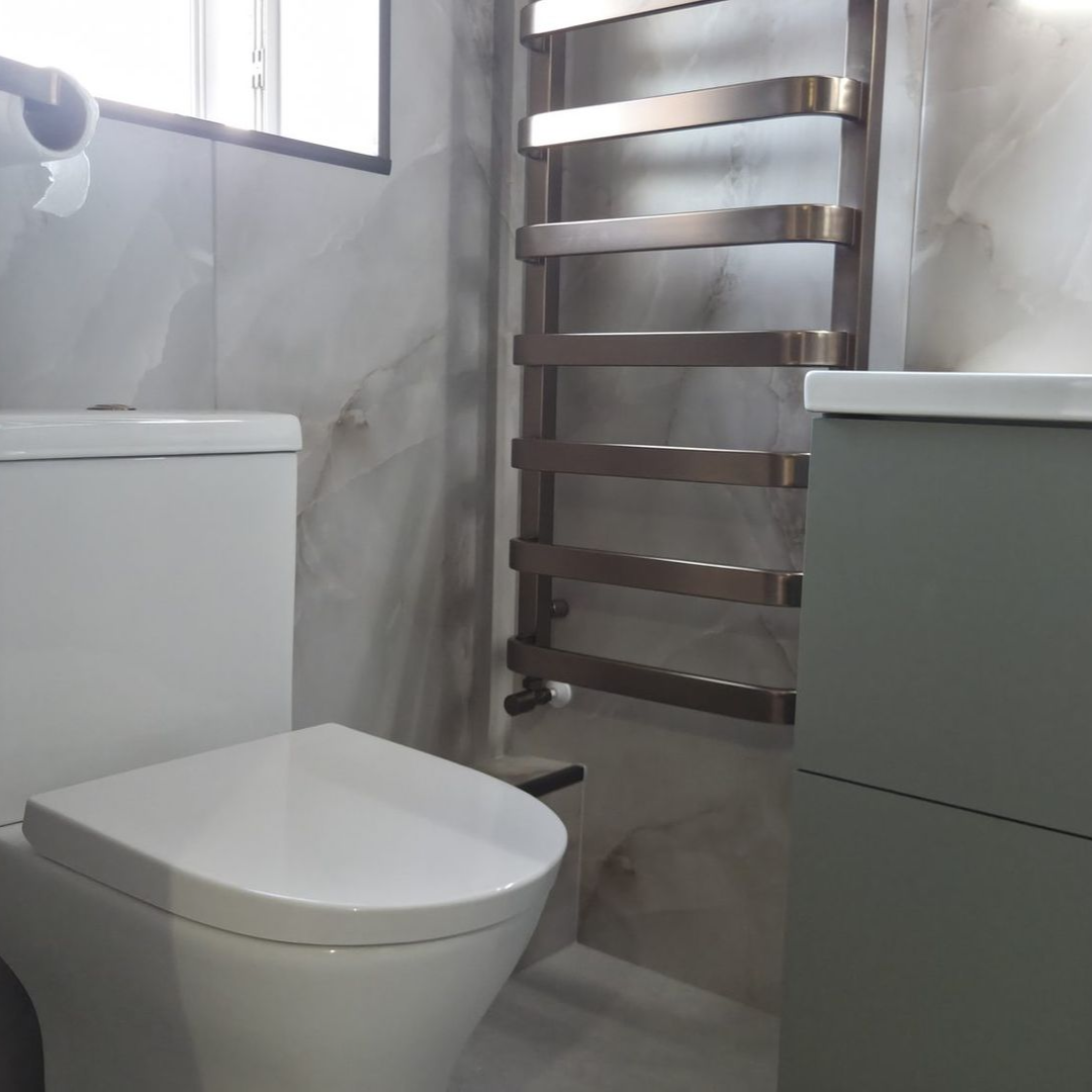 Marble-effect shower room with sage green vanity and bronze towel rail