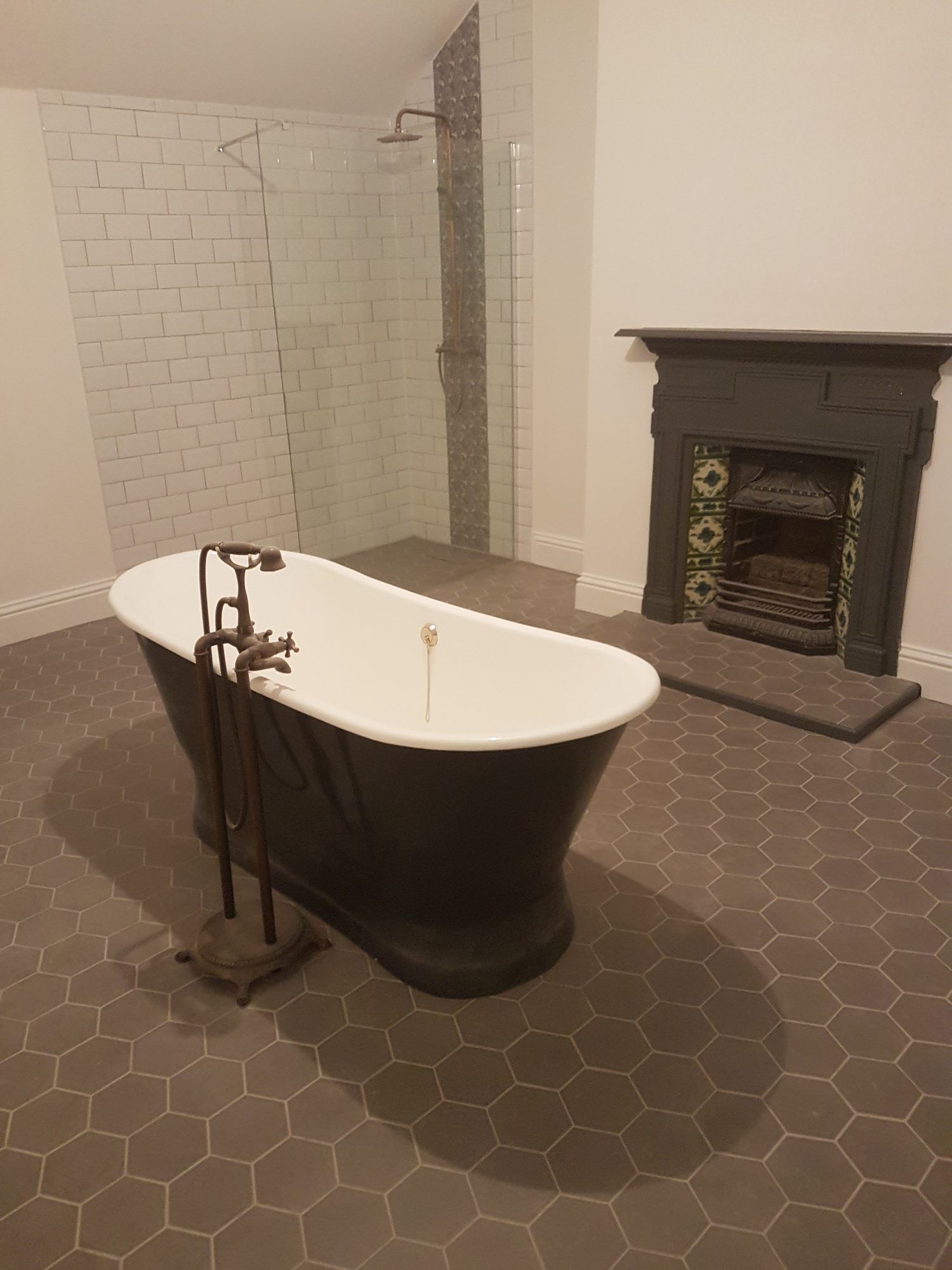 Period bathroom with roll-top bath and hexagon floor tiles