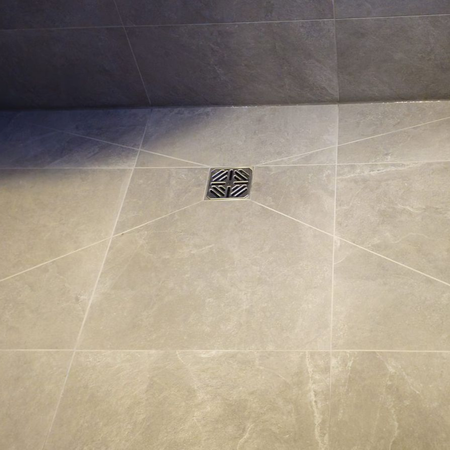 Wet room floor laid with large-format tiles