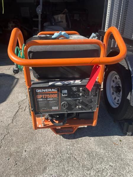 Orange-framed Generac generator on a trailer, parked outdoors on pavement.