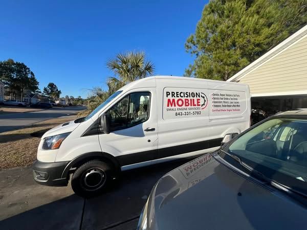White service van with “Precision Mobile” logo parked beside a car in a driveway under a blue sky