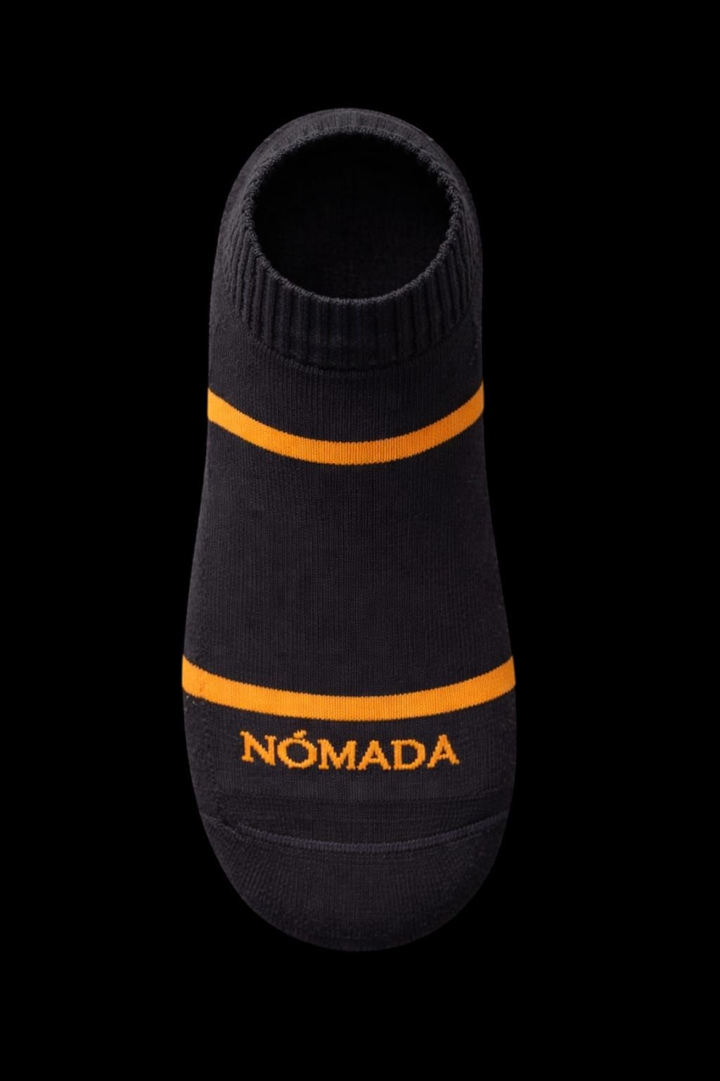 Calcetín negro acanalado con rayas naranjas y la marca “NÓMADA” sobre fondo negro.