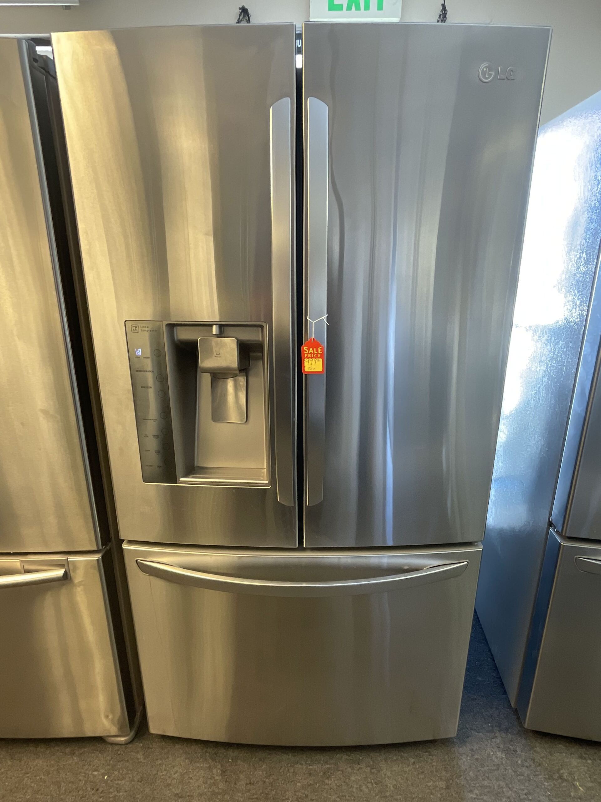 A row of stainless steel refrigerators are lined up in a room.