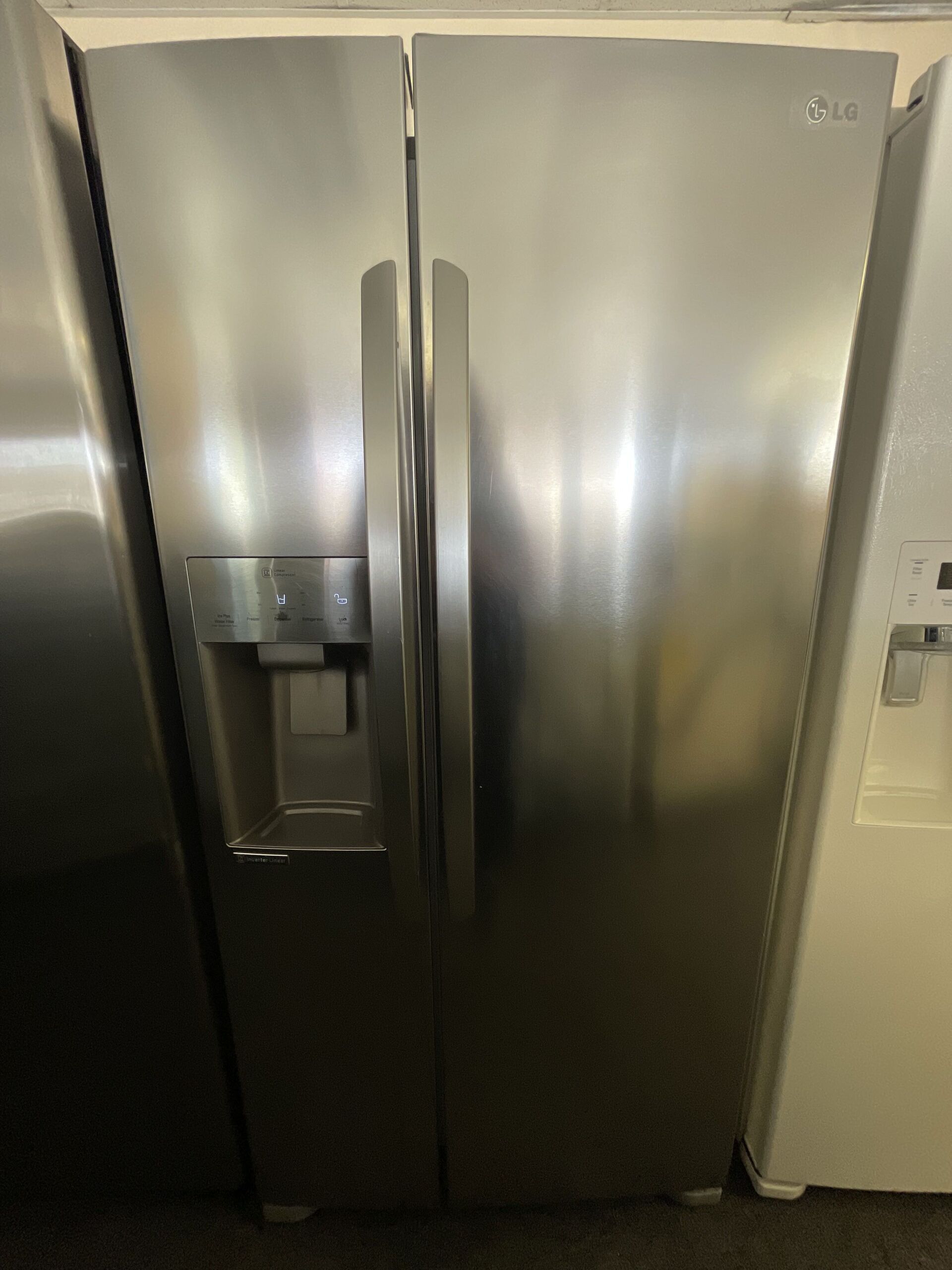 A stainless steel refrigerator with a water dispenser on the door.