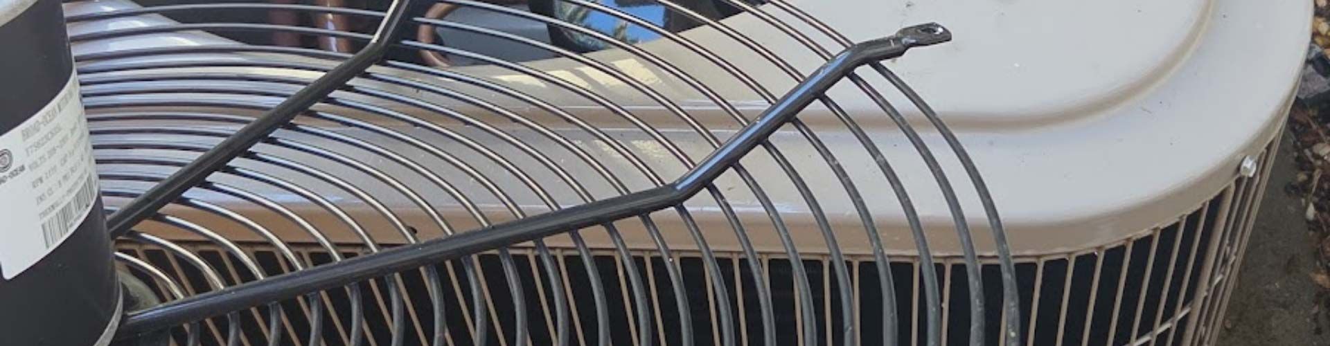 Close-up of a metal grill grate on a round outdoor fire pit or smoker lid