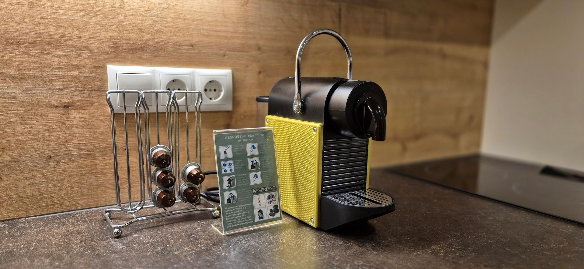 Küchenarbeitsplatte mit Kaffeemaschine, Tasse und kleinem Gerät neben einer Steckdose