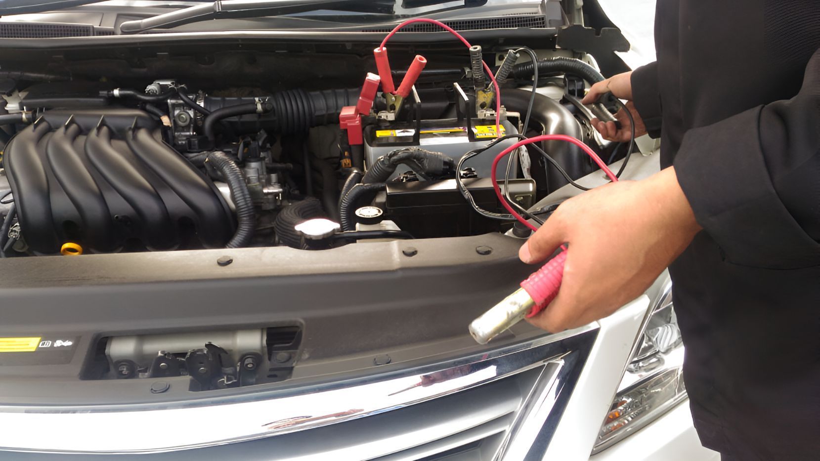 A Person is Charging a Car Battery With Jumper Cables — K & T Ballina Mechanical In Ballina, NSW