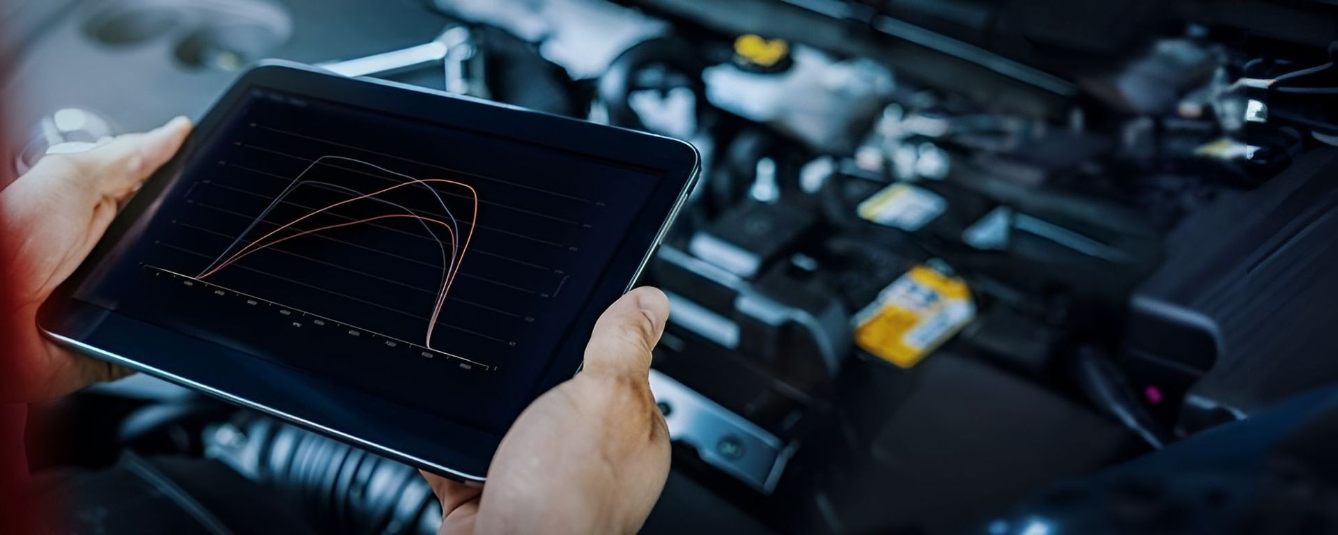 A Person is Holding a Tablet in Front of a Car Engine — K & T Ballina Mechanical In Ballina, NSW