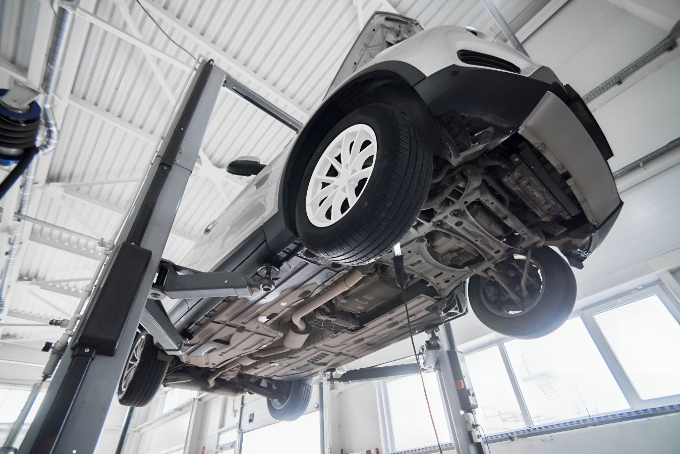 A Car is Sitting on a Lift in a Garage — K & T Ballina Mechanical In Ballina, NSW