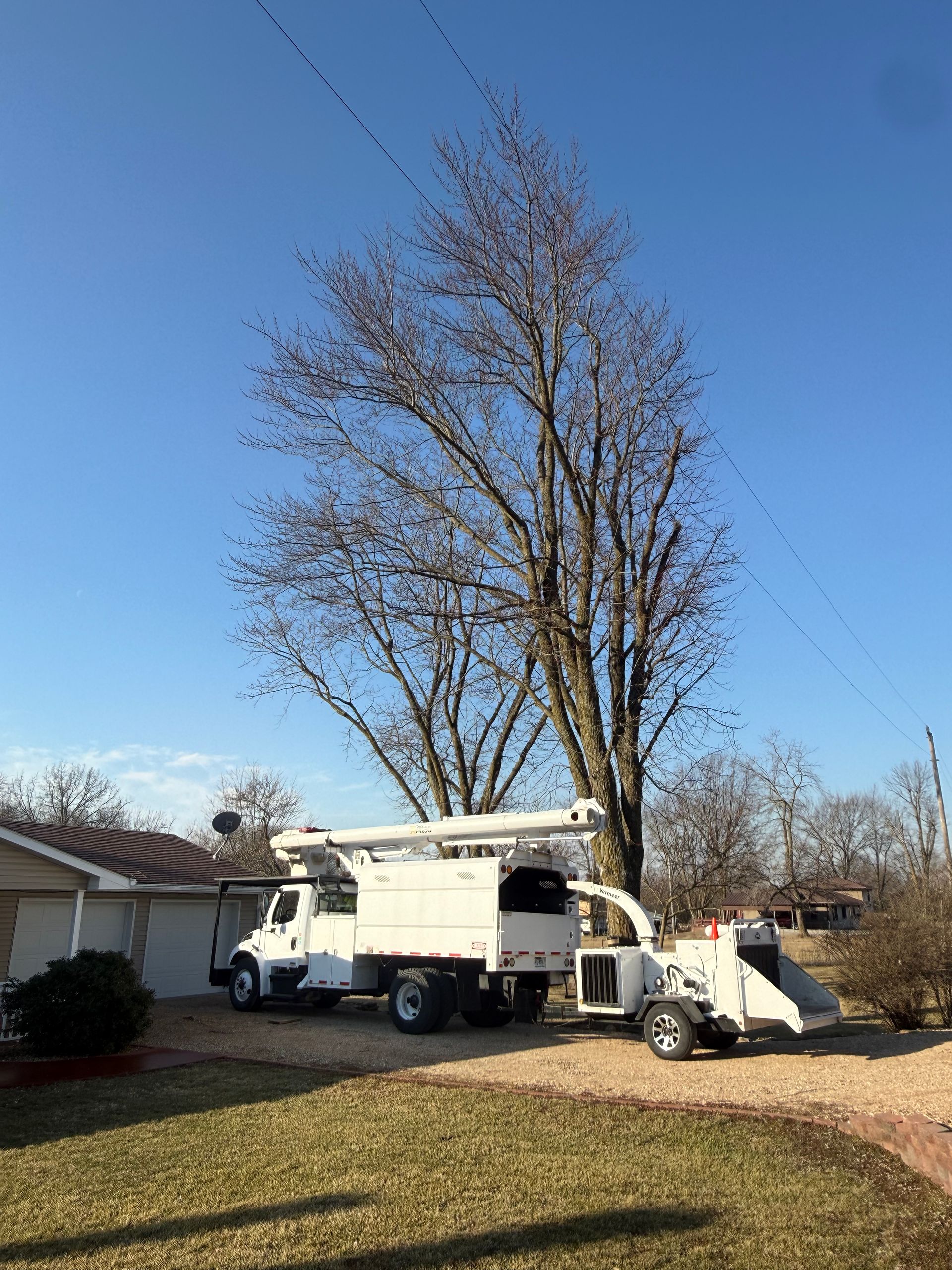 A white truck is parked in front of a small house.