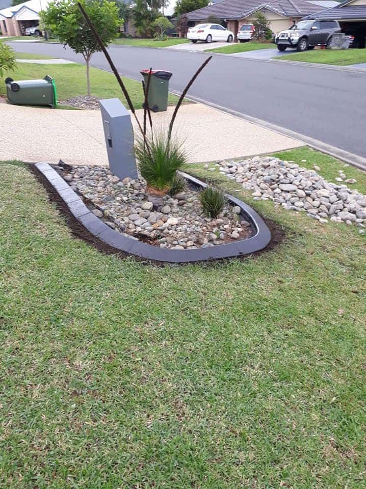 A Small Garden Bed With Pebbles and Grasses — Brett's Continuous Garden Edges In Wauchope, NSW