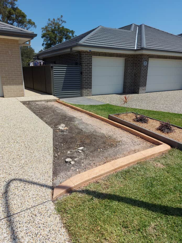 A Garden Bed Bordered by Concrete Near a Driveway — Brett's Continuous Garden Edges In Lakewood, NSW