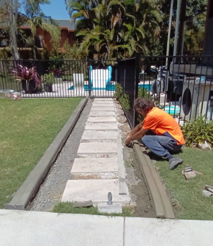 Man Installs Edging on a Stone Path — Brett's Continuous Garden Edges In Wauchope, NSW